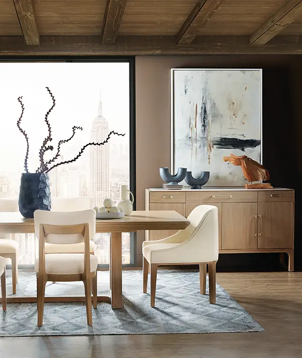 Light wood dining table with upholstered chairs and a sideboard