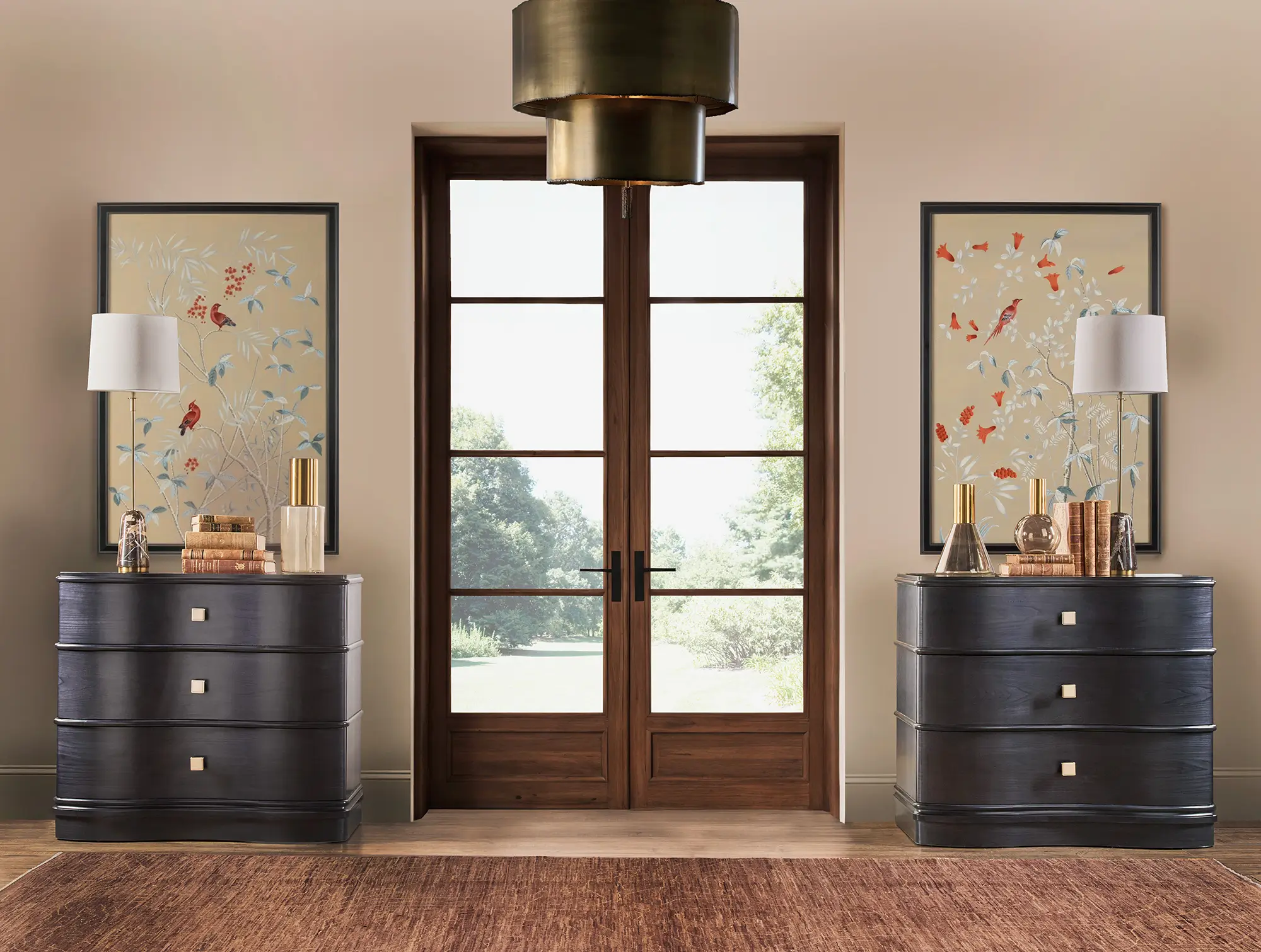 Pair of dark curved chests flanking a set of glass garden doors in a bright hallway