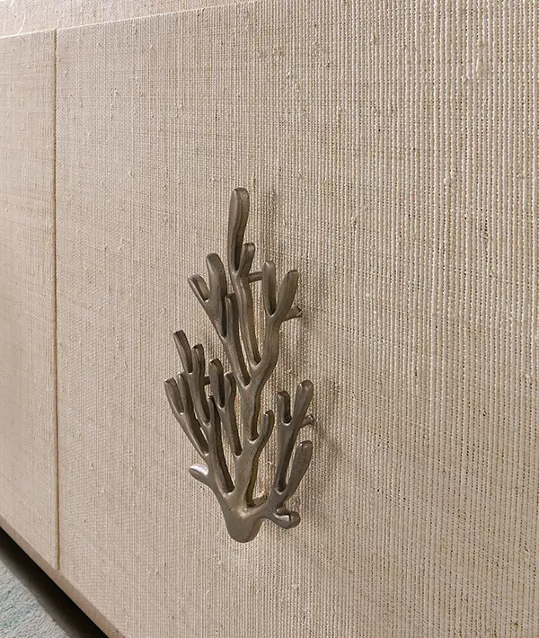 Coral-shaped decorative accent against a woven grasscloth wall