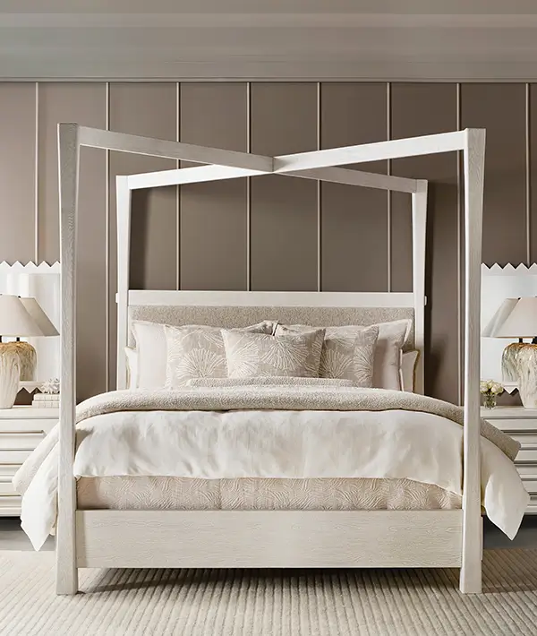 Light wood bed with a woven headboard and layered white bedding