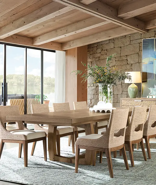 Oak dining table and upholstered chairs under a beamed ceiling