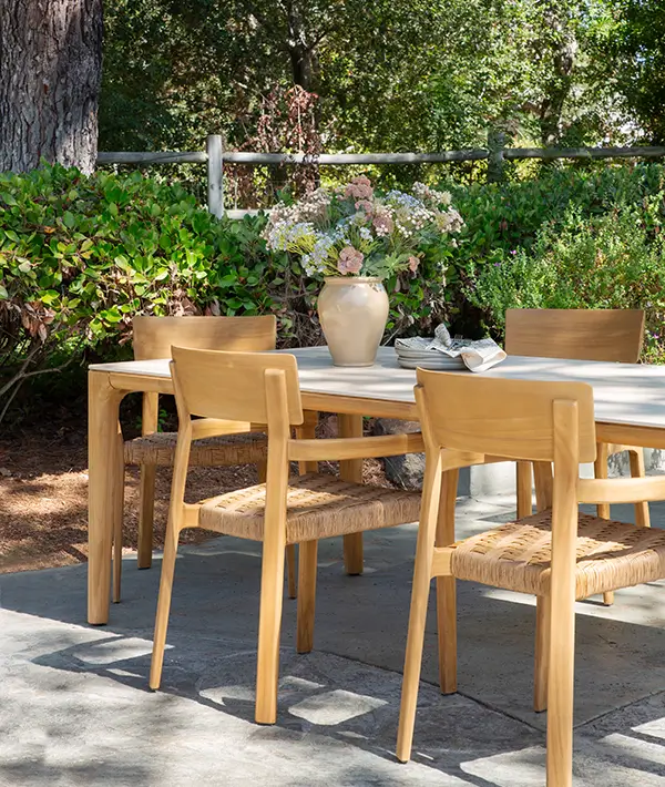 Outdoor dining table and chairs on a shaded garden terrace