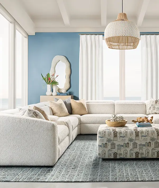 Cream sectional sofa with patterned cushions in a blue and white living room